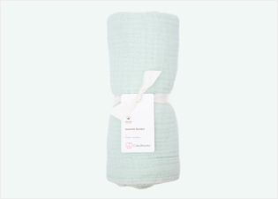 Mint Cradlewise Muslin Blanket rolled and secured with a white ribbon, with a Cradlewise product tag attached.